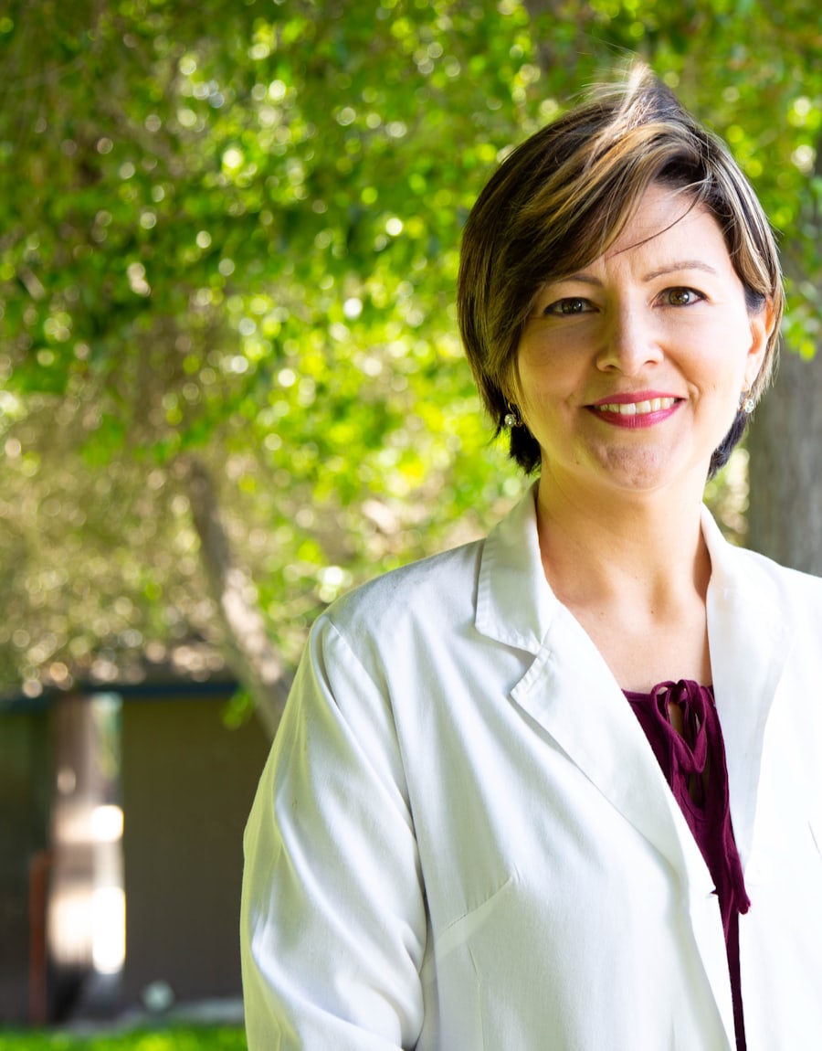 Marina Reis, nutricionista, de jaleco branco, sorrindo em um jardim